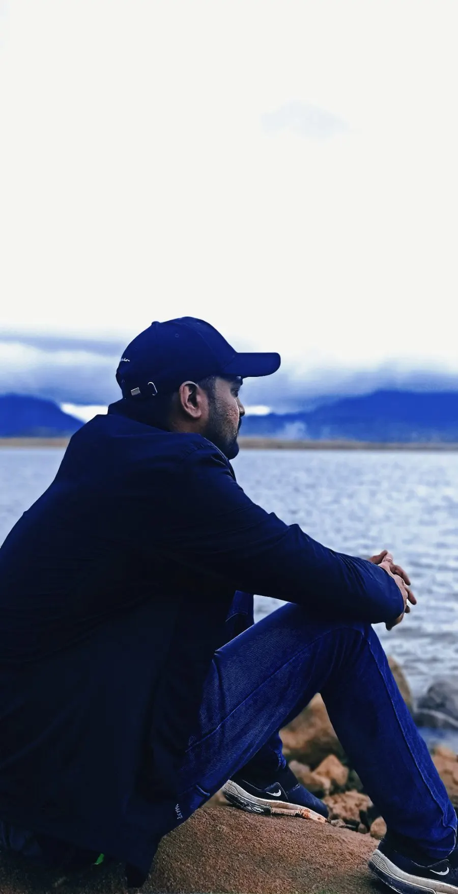 Tushar sitting by a lake at dusk